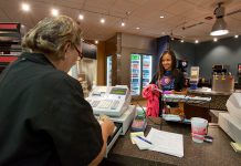 Bistro server talking with customer over the counter.