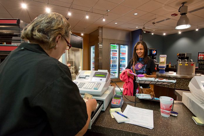 Bistro server talking with customer over the counter.