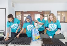 Students putting potting soil in planters.