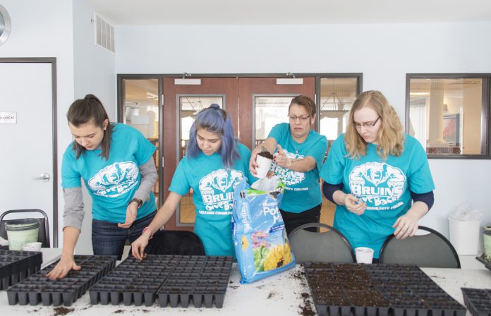 Students putting potting soil in planters.