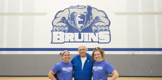 Volleyball players Madison Jones and Kameron Haley stand with Mick Haley in the Miller gym.