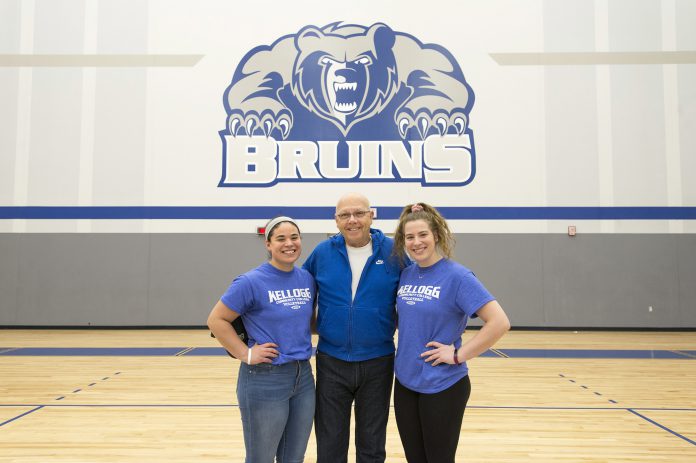 Volleyball players Madison Jones and Kameron Haley stand with Mick Haley in the Miller gym.