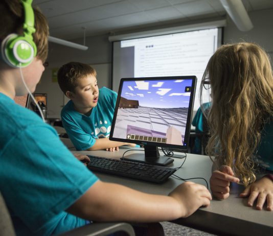 Kids playing computer game Minecraft.