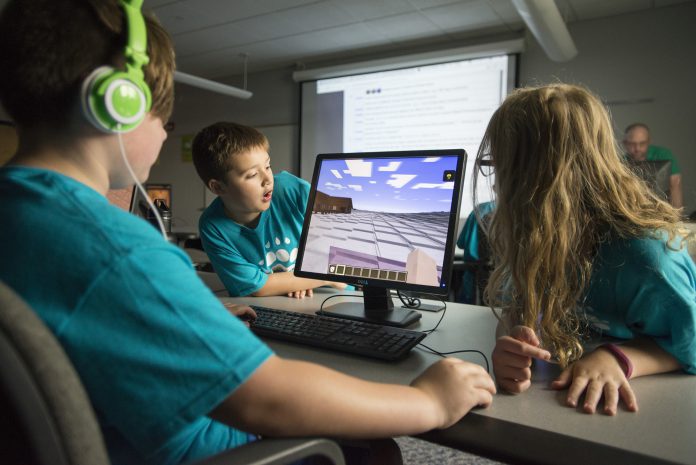 Kids playing computer game Minecraft.