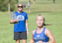 Head KCC Cross-Country Coach Erin Lane watches a runner finish at the Knight-Raider Invitational in Grand Rapids in 2019.