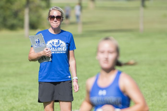 Head KCC Cross-Country Coach Erin Lane watches a runner finish at the Knight-Raider Invitational in Grand Rapids in 2019.