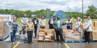 KCC staff members pose with boxes of food outside during a Fresh Food Distribution event.