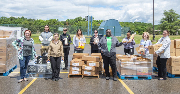 KCC staff members pose with boxes of food outside during a Fresh Food Distribution event.