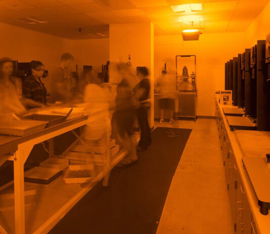 A view of the Kellogg Community College darkroom under red safelights.