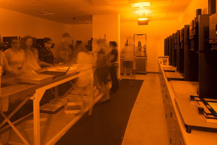 A view of the Kellogg Community College darkroom under red safelights.