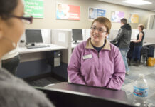 A student worker assists a visitor to the Hub.