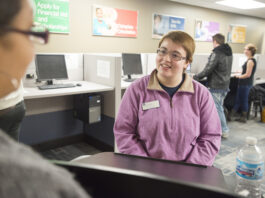 A student worker assists a visitor to the Hub.