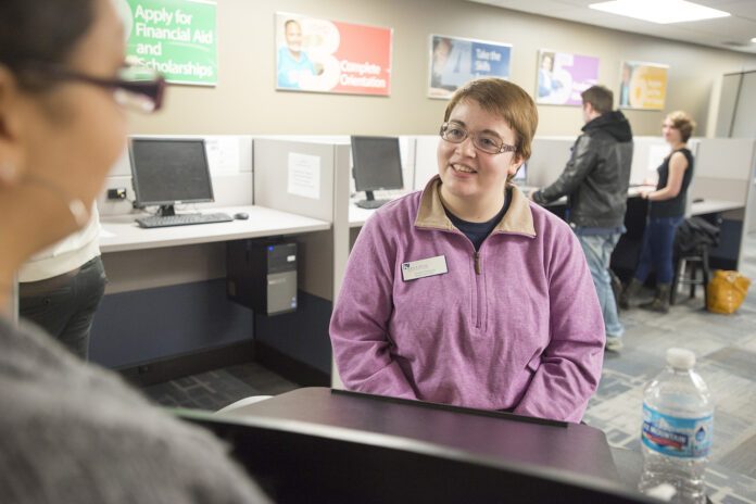 A student worker assists a visitor to the Hub.