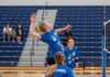 A volleyball player jumps to spike the ball.