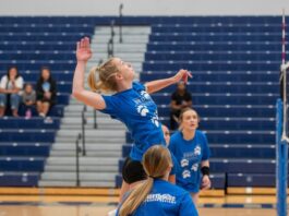 A volleyball player jumps to spike the ball.