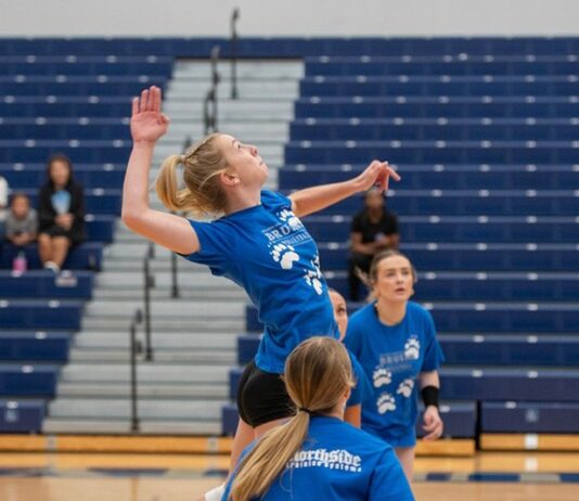 A volleyball player jumps to spike the ball.