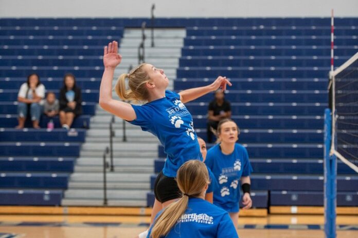 A volleyball player jumps to spike the ball.